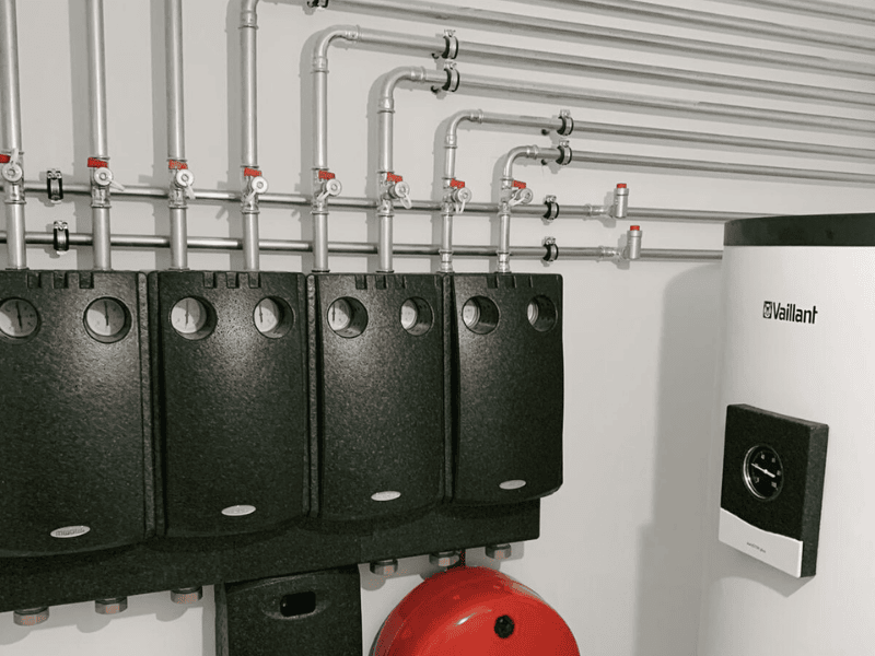 Heizsystem im Keller – Referenzprojekt von Del Missier & Bergmann Warmwasserspeicher von Vaillant und durchdachte Rohrleitungsführung für effiziente Energieversorgung.